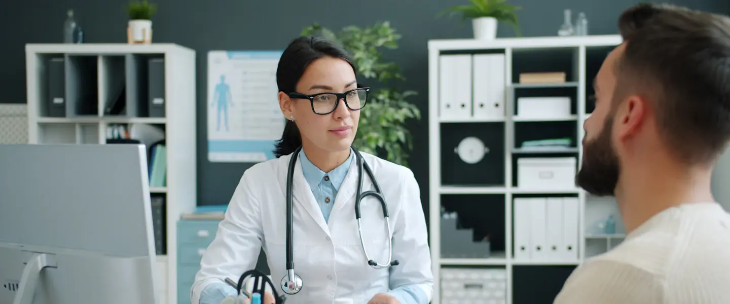 A doctor talking with a patient across her desk